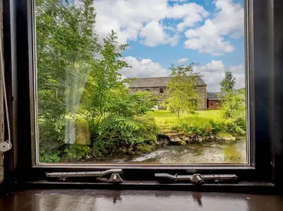 a window with a view of a house and a river at 4 Bed in Cockermouth oc-sz098 in Lorton