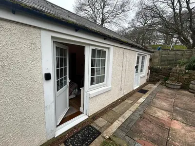 a small house with a door and a patio at Hollyside Lodge in Carlisle