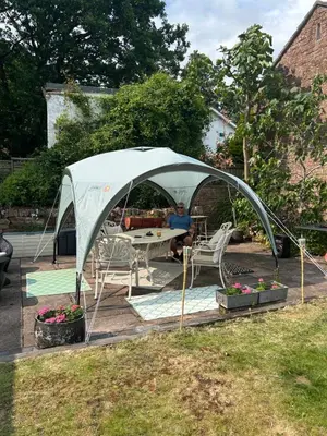 a man sitting at a table under a tent at Hollyside Lodge in Carlisle