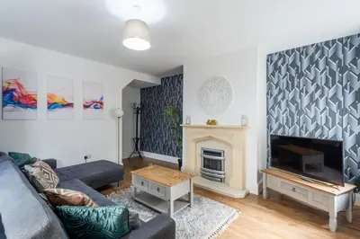 a living room with a couch and a fireplace at 5 Bed Workington House with Parking Near Station in Workington