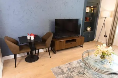 a living room with a table and a flat screen tv at Cosy 1-Bedroom Flat, Walk to Beaches in Troon