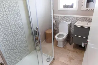 a bathroom with a shower and a toilet and a sink at Cosy 1-Bedroom Flat, Walk to Beaches in Troon