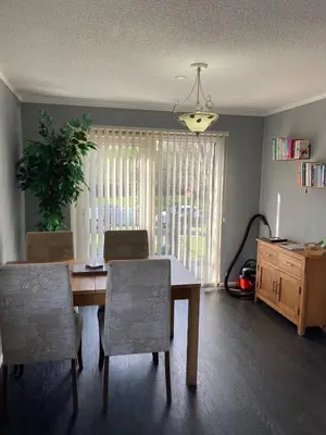 a dining room with a table and chairs and a window at Blackpool chalet - free parking in Moffat