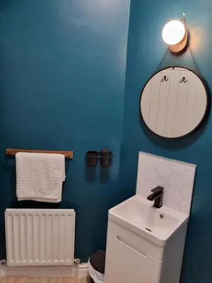 a bathroom with a white sink and a blue wall at No3 Spacious Apartment Cockermouth in Cockermouth