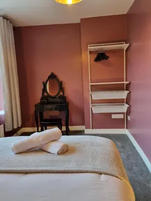 a bedroom with a bed with a mirror and a vanity at No3 Spacious Apartment Cockermouth in Cockermouth