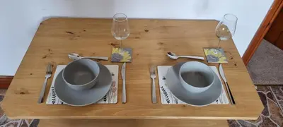 a wooden table with two plates and two wine glasses at The Creamery High Harrington in Harrington