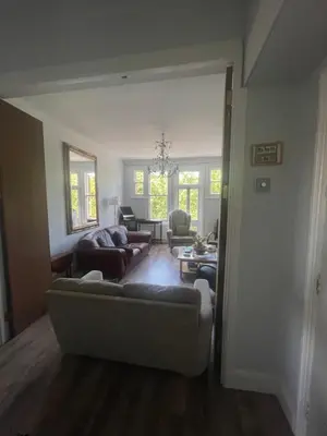 a living room with a couch and chairs and a table at Bright peaceful room 4th floor in front Battersea park in Moffat