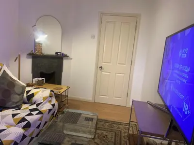 a living room with a tv and a couch at Elegant, Cozy 1 Bedroom Flat In Heart Of London Pimlico in Moffat
