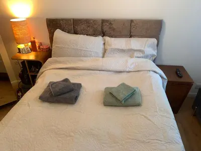 a bed with two towels and two pillows on it at Elegant, Cozy 1 Bedroom Flat In Heart Of London Pimlico in Moffat