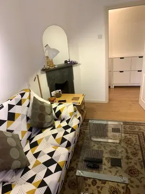 a living room with a couch and a table at Elegant, Cozy 1 Bedroom Flat In Heart Of London Pimlico in Moffat