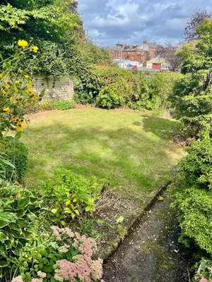a garden with a yard with grass and flowers at Relax by the River, at Millgreen House in Dumfries