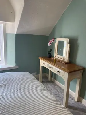 a bedroom with a dresser with a mirror and a bed at Relax by the River, at Millgreen House in Dumfries