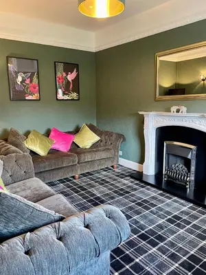 a living room with two couches and a fireplace at Relax by the River, at Millgreen House in Dumfries