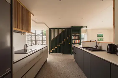 a kitchen with white counters and a book shelf at Swallow Barn at Greenclose Farm in Penrith