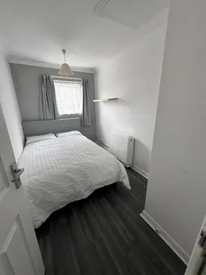 a bedroom with a white bed and a window at Honey House in Moffat