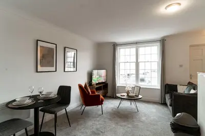 a living room with a table and chairs and a couch at Lovely 1 Bed Harbour-side Apartment - Sea Views in Whitehaven