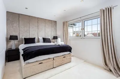 a bedroom with a large bed and a window at No22 Shalloch House - Donnini Apartments in Ayr