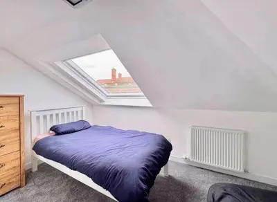 a bedroom with a bed and a skylight at Central Charming Sea View Loft Flat in Troon
