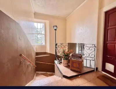 a room with a door and a table with a plant at Central Charming Sea View Loft Flat in Troon