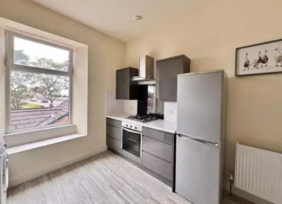 a kitchen with a stainless steel refrigerator and a window at Central Charming Sea View Loft Flat in Troon