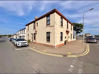 a building on the side of a street with parked cars at Central Charming Sea View Loft Flat in Troon