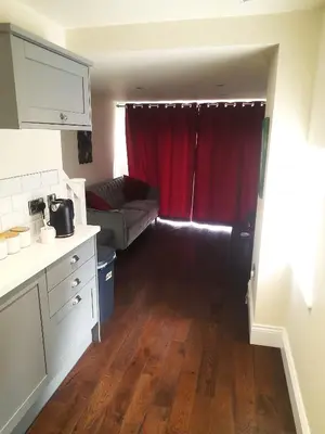 a living room with a couch and a red curtain at Kirkcudbright Holiday Apartments - Apartment B in Kirkcudbright