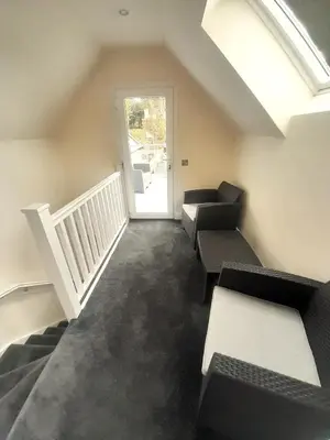 a living room with couches and a staircase with a window at Kirkcudbright Holiday Apartments - Apartment B in Kirkcudbright