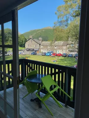 a balcony with a table and a green chair at The Little Inn at Grasmere in Grasmere