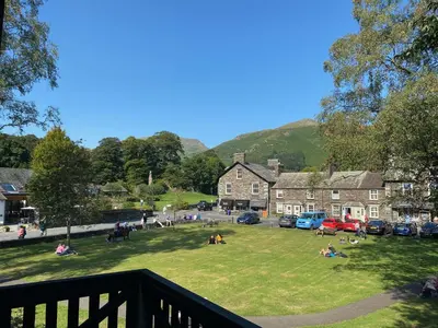 a group of people sitting on the grass in a park at The Little Inn at Grasmere in Grasmere