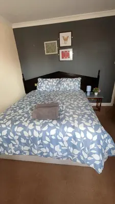 a bedroom with a bed with a blue and white comforter at QueensBerry Annan in Annan