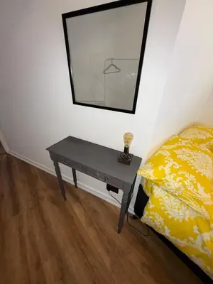 a table in a room with a bed and a mirror at 3 bedroom traditional apartment in Ayr