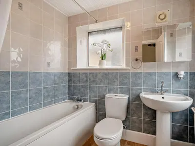 a bathroom with a toilet and a sink and a tub at 1 Bed in Keswick 96314 in Keswick