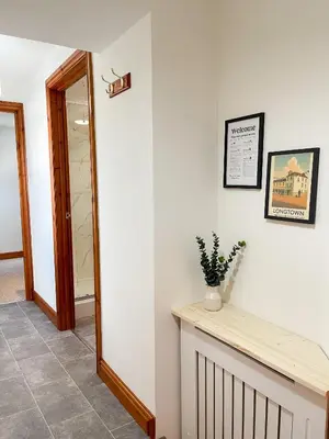 a hallway with white walls and a mirror at Borders Retreat, Cosy 1 Bed Flat - 3miles from M6 Jct45 - near A75, Gretna & Carlisle in Longtown