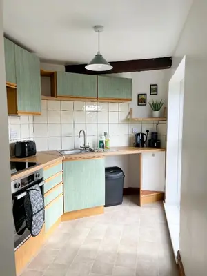 a kitchen with green cabinets and a sink at Borders Retreat, Cosy 1 Bed Flat - 3miles from M6 Jct45 - near A75, Gretna & Carlisle in Longtown