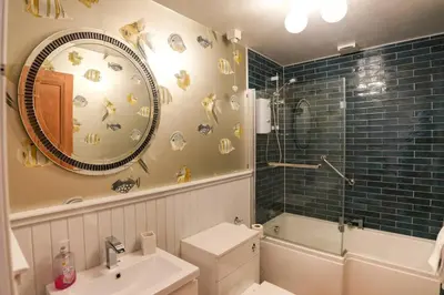 a bathroom with a toilet and a sink and a mirror at Seabreeze in Prestwick in Prestwick