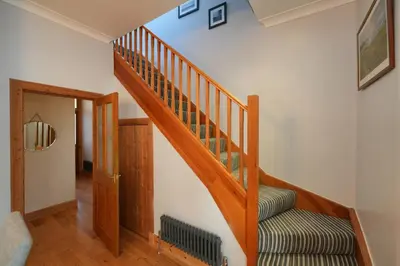 a wooden staircase in a home with a stair case at Seabreeze in Prestwick in Prestwick