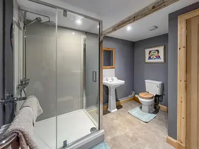 a bathroom with a shower and a toilet and a sink at Townhead Mill in Dumfries