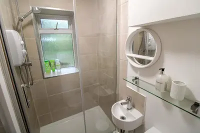 a bathroom with a shower and a sink and a mirror at Lorton View, nestles on the fellside with walks from the door close to Lorton in Lorton