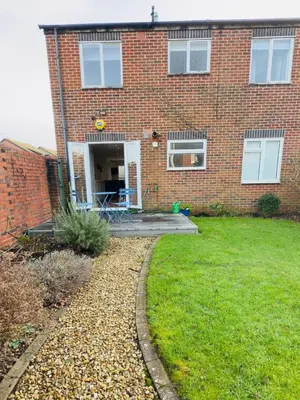 a brick house with a patio in the yard at Stylish Two-Bedroom Flat with Garden Near Henley Town Centre in Moffat
