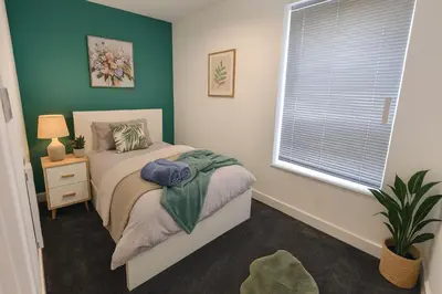 a small bedroom with a bed and a window at Armstrong St - Cosy 3 Bedroom Home in Workington