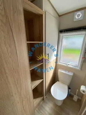 a small bathroom with a toilet and a window at Wanderers Haven, Brigham, Cockermouth, Cumbria in Brigham