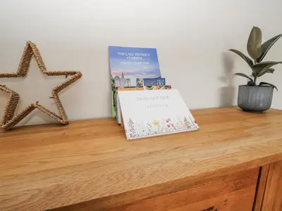 a book sitting on top of a wooden table with a starfish at Daisy Cottage in Wigton