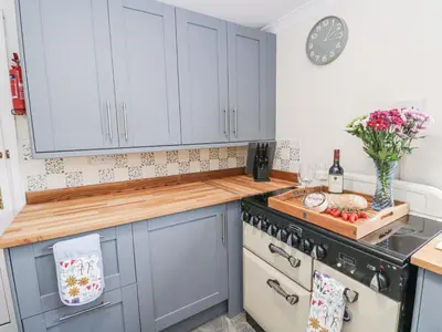 a kitchen with blue cabinets and a counter top at Daisy Cottage in Wigton