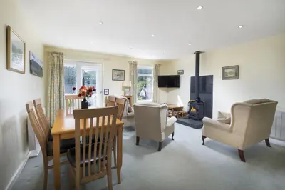 a living room with a dining room table and chairs at 22 Thrang Brow - Langdale Valley in Chapel Stile