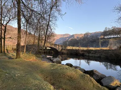 a bridge over a river with a train crossing it at 22 Thrang Brow - Langdale Valley in Chapel Stile
