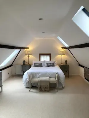 a bedroom with a white bed and two windows at The Cart Barn in Moffat