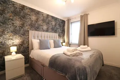 a bedroom with a bed with a tv on the wall at Cosy 1 bed flat in central Ayr in Ayr