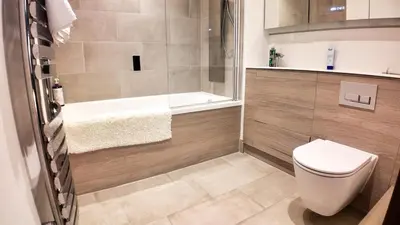 a bathroom with a shower and a toilet and a tub at The Sunrise Den, Modern 2-Bed Apartment, Free Parking in Yarrow
