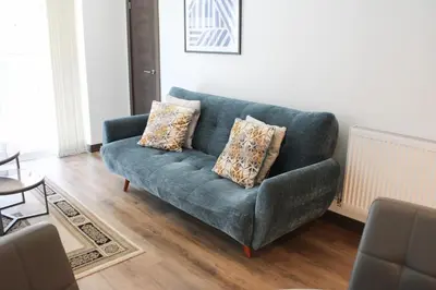 a living room with a blue couch with two pillows at The Sunrise Den, Modern 2-Bed Apartment, Free Parking in Yarrow