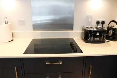 a kitchen counter with a stove top in a kitchen at The Sunrise Den, Modern 2-Bed Apartment, Free Parking in Yarrow